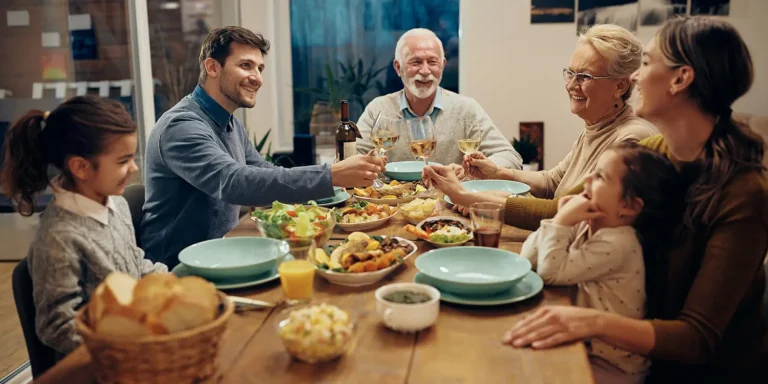 Generational family toasting over dinner. Notes Regarding Intergenerational Sharing of Homes