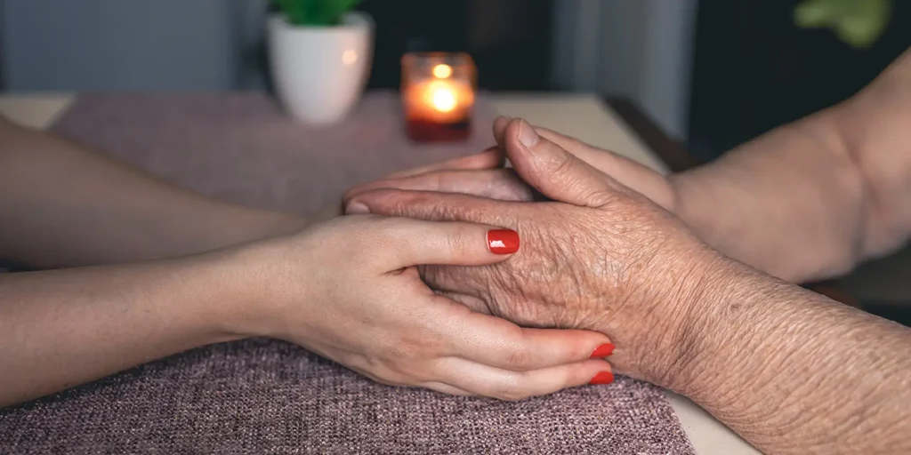 Young family member holding elderly persons hands - Understanding the Role of an Executor