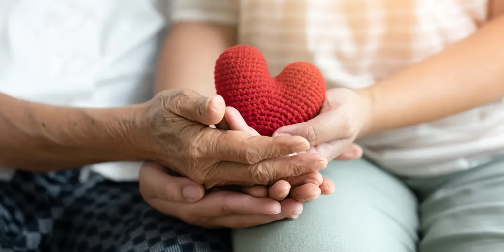 Should I leave a charitable gift in my will? Elderly lady giving a gift.