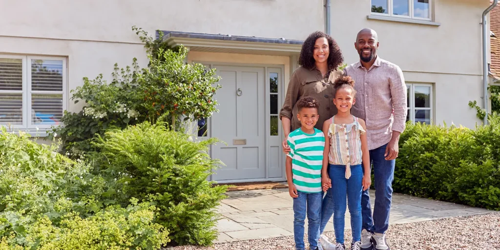 Family standing outside their beautiful new home. Nantes Solicitors Guide To Conveyancing in Dorset - Part One.