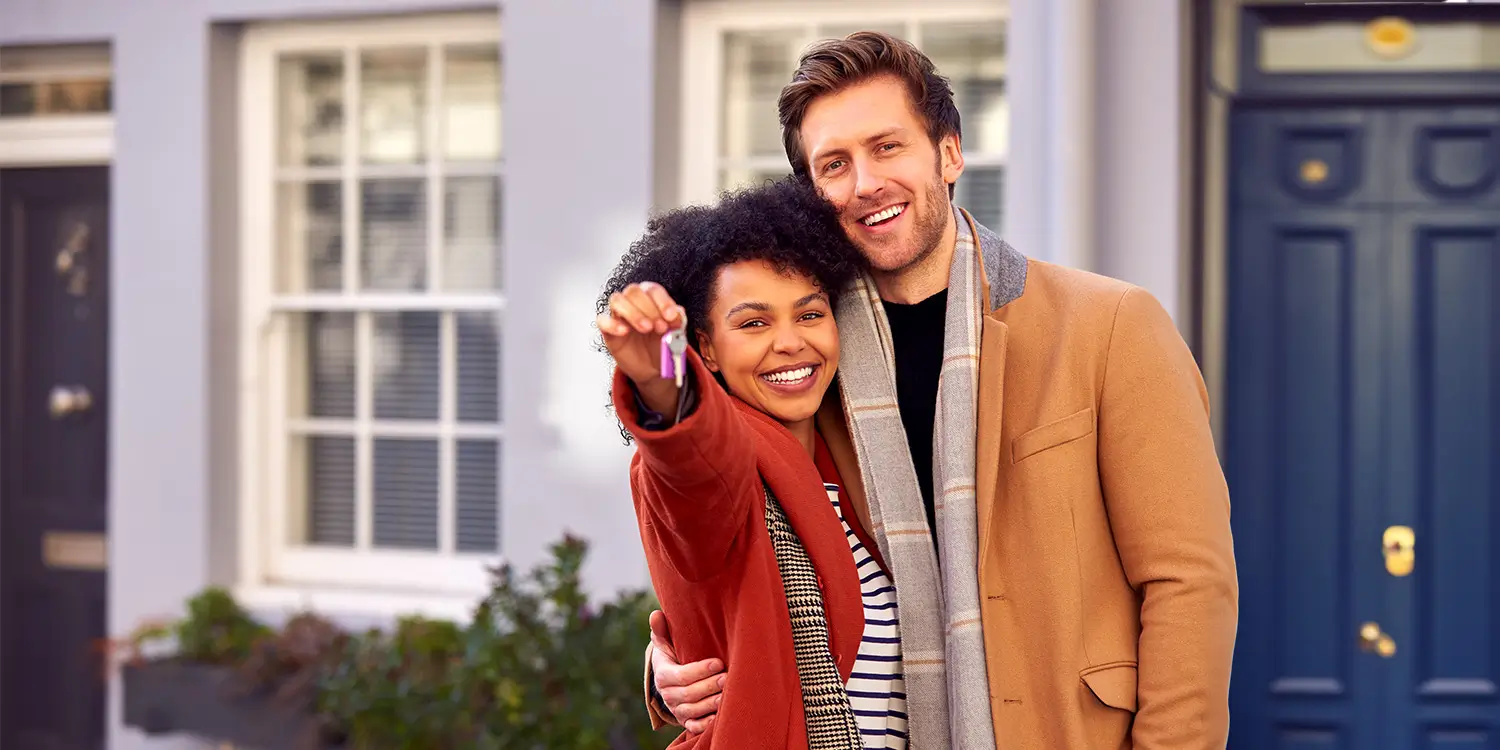 Couple standing outside their beautiful new home. Nantes Solicitors Guide To Conveyancing in Dorset - Part Two