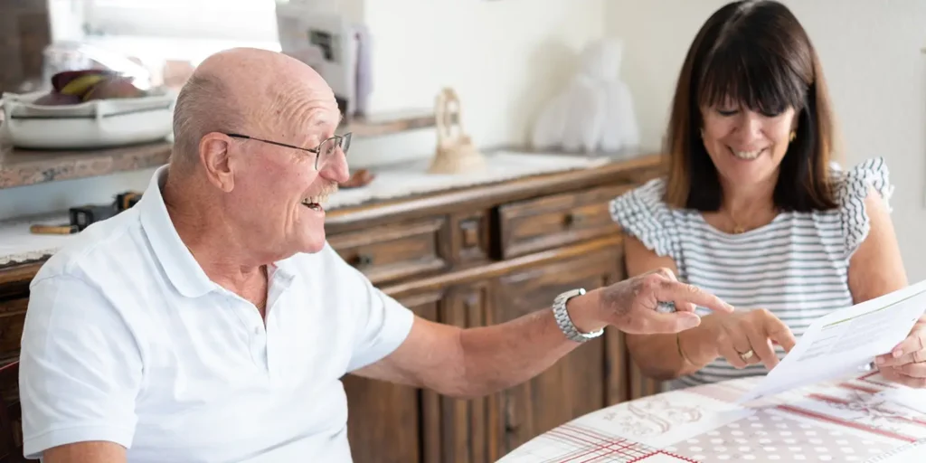 Elderly man and woman reviewing documents together, illustrating family carers’ legal rights to reimbursement under Rogers v Wills 2025 High Court ruling