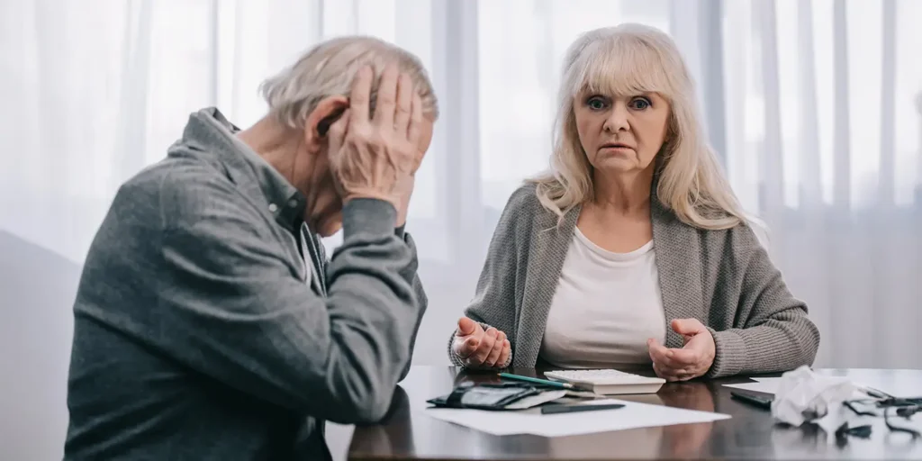 Unhappy couple reviewing pension documents during divorce, representing Cherise’s reflection on 25 years of pension sharing reform in family law at Nantes.