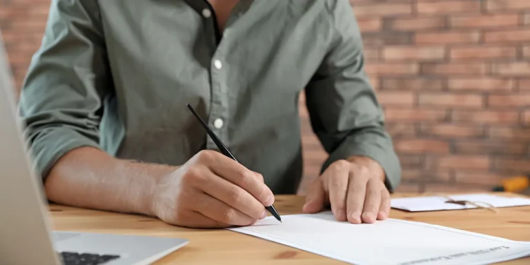 Person signing legal document while updating a will after major life changes