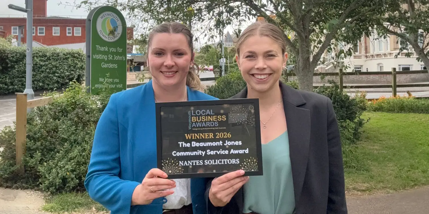 Molly Miles and Esmia Steenkamp from Nantes Solicitors holding the Community Service Award at the Weymouth Business Awards.